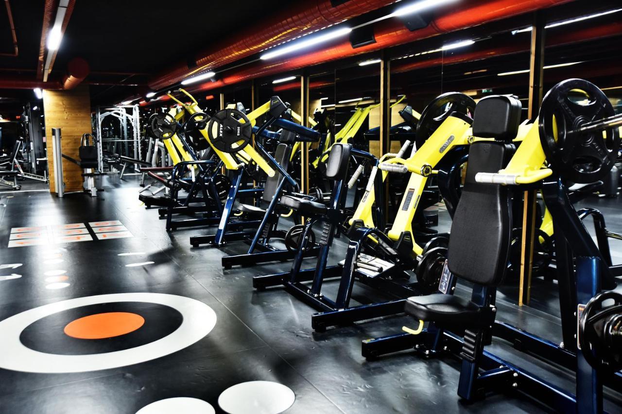 Dosso Dossi Hotels & Spa Downtown Istambul Exterior foto The photo shows a modern gym interior featuring various exercise machines. There are several yellow and black weight training machines aligned in rows, with a focus on strength training equipment. The flooring is dark with circular patterns, includin