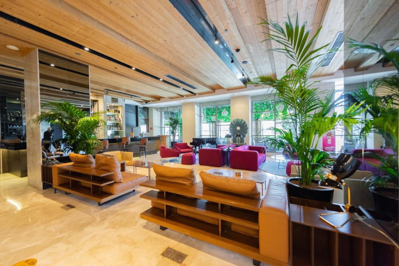 Dosso Dossi Hotels & Spa Downtown Istambul Exterior foto The photo shows a modern interior of a lobby or lounge area. It features wooden ceilings and a mix of natural and contemporary design elements. There are several comfortable seating arrangements, including plush sofas in various colors such as beige 