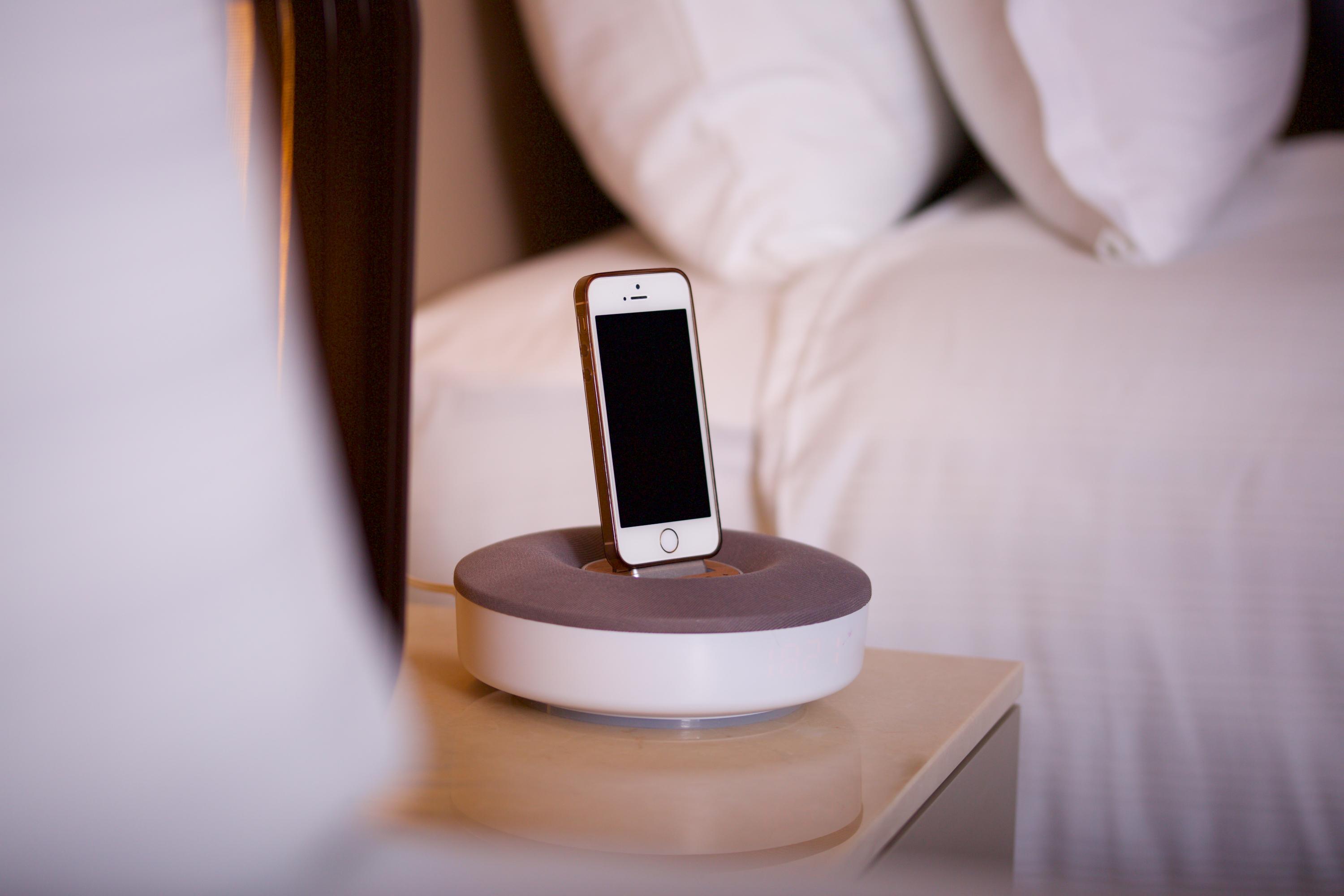 Dosso Dossi Hotels & Spa Downtown Istambul Exterior foto The photo shows a smartphone placed on a charging dock. The dock has a circular base with a gray top and a white bottom. The smartphone is upright in the dock, facing forward, and has a blank screen. There are neatly arranged pillows visible in the b