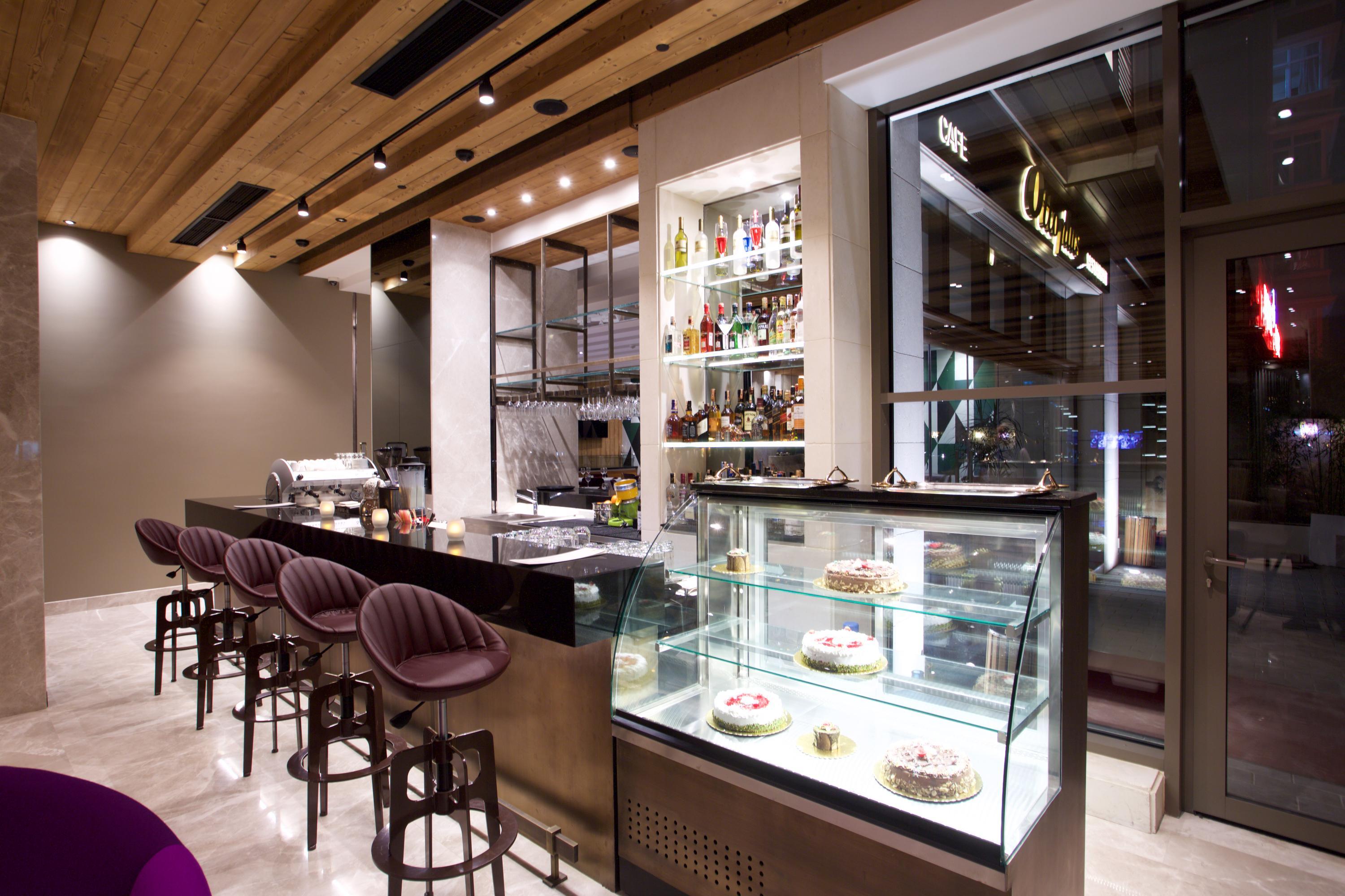 Dosso Dossi Hotels & Spa Downtown Istambul Exterior foto The photo shows the interior of a modern restaurant or café. There is a sleek bar area with a few high stools and a polished countertop. Behind the bar, shelves are stocked with various bottles, indicating a selection of drinks. To the right, there's