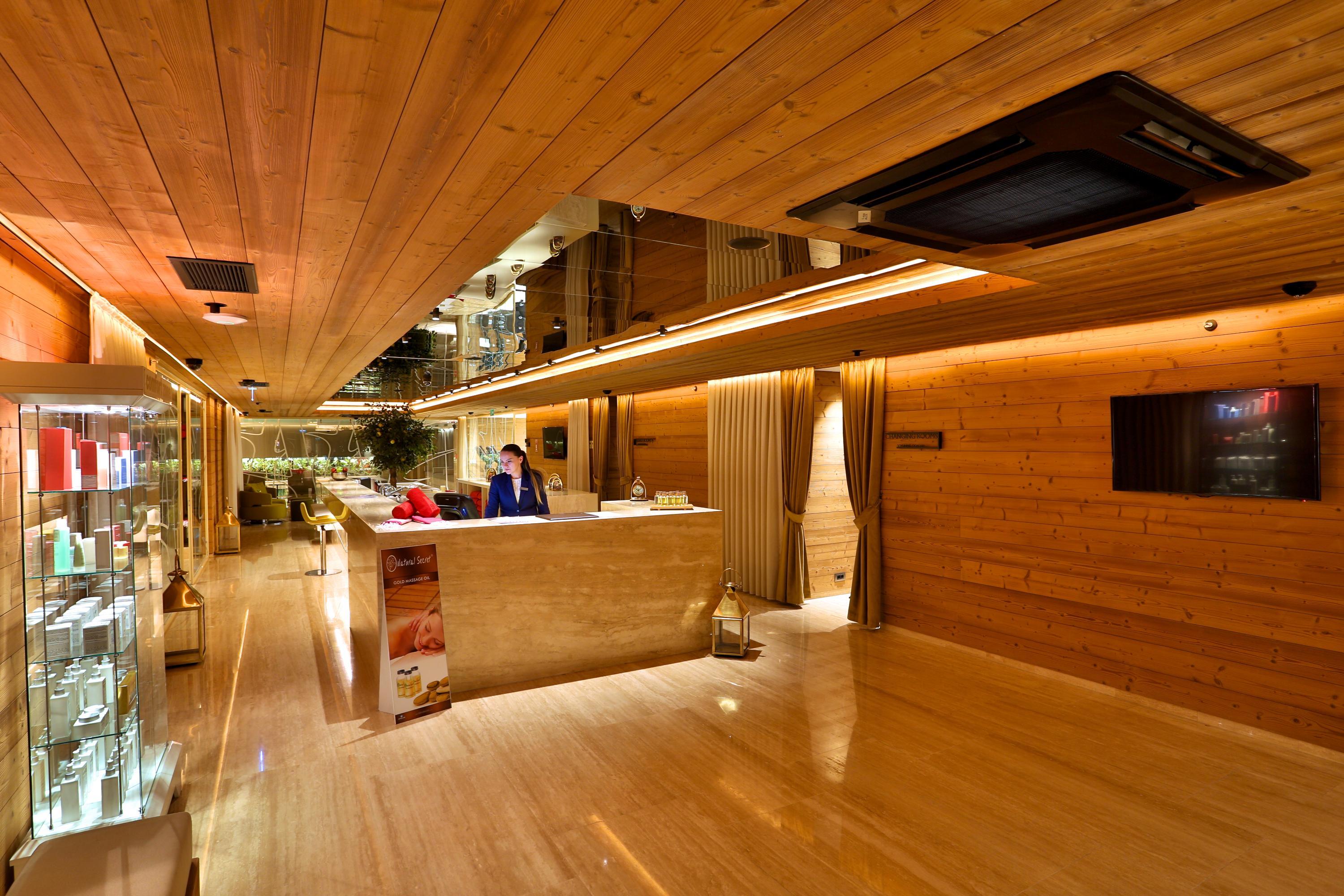 Dosso Dossi Hotels & Spa Downtown Istambul Exterior foto The photo depicts a modern reception area or lobby with a warm and inviting design. The walls and ceiling are finished in wood, creating a cozy atmosphere. There is a polished stone or marble floor that reflects light, enhancing the brightness of the