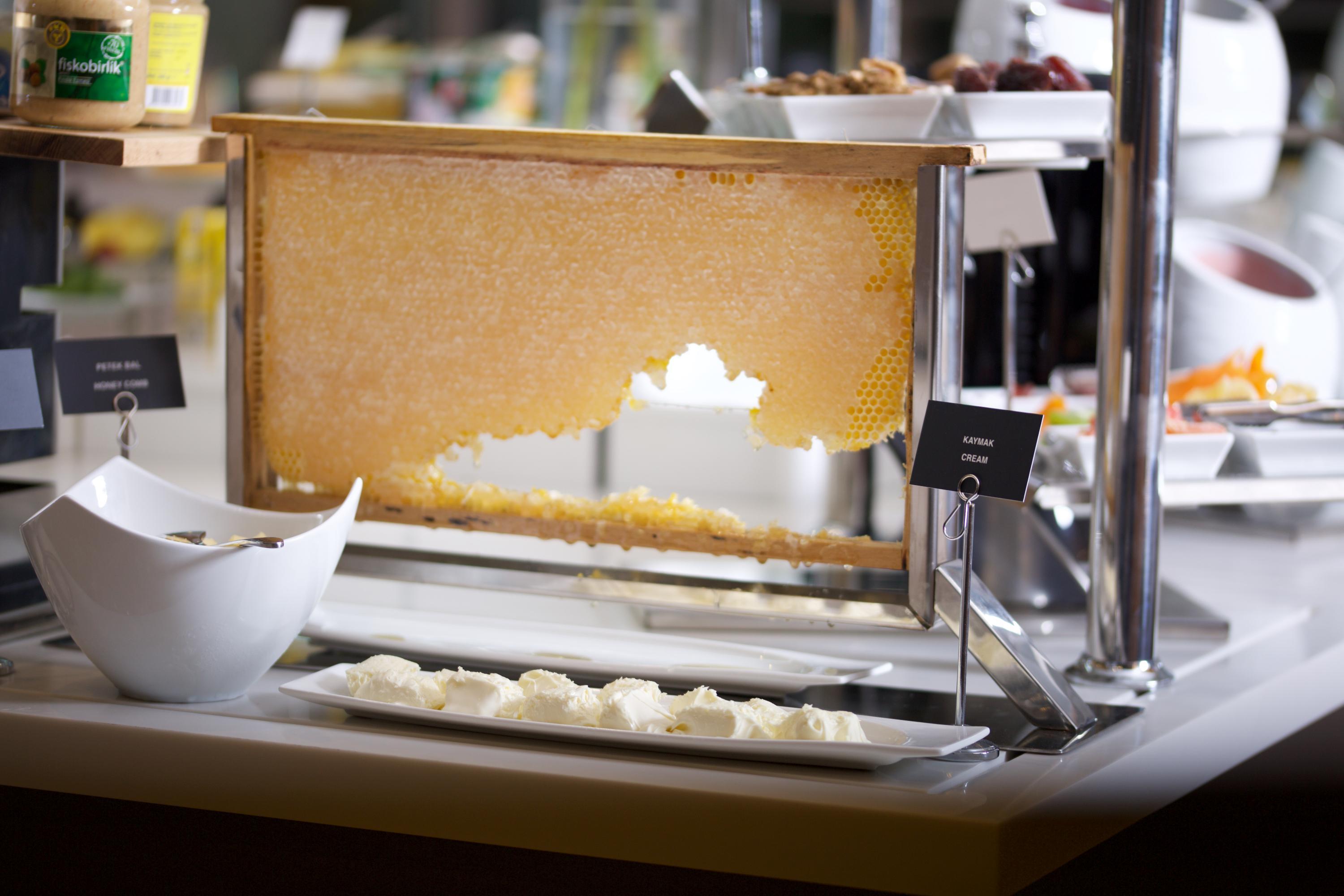 Dosso Dossi Hotels & Spa Downtown Istambul Exterior foto The photo shows a buffet setup featuring a large piece of honeycomb displayed in a frame, from which honey can be extracted. Below the honeycomb, there is a white dish containing small portions of what appears to be a creamy substance, likely a dairy