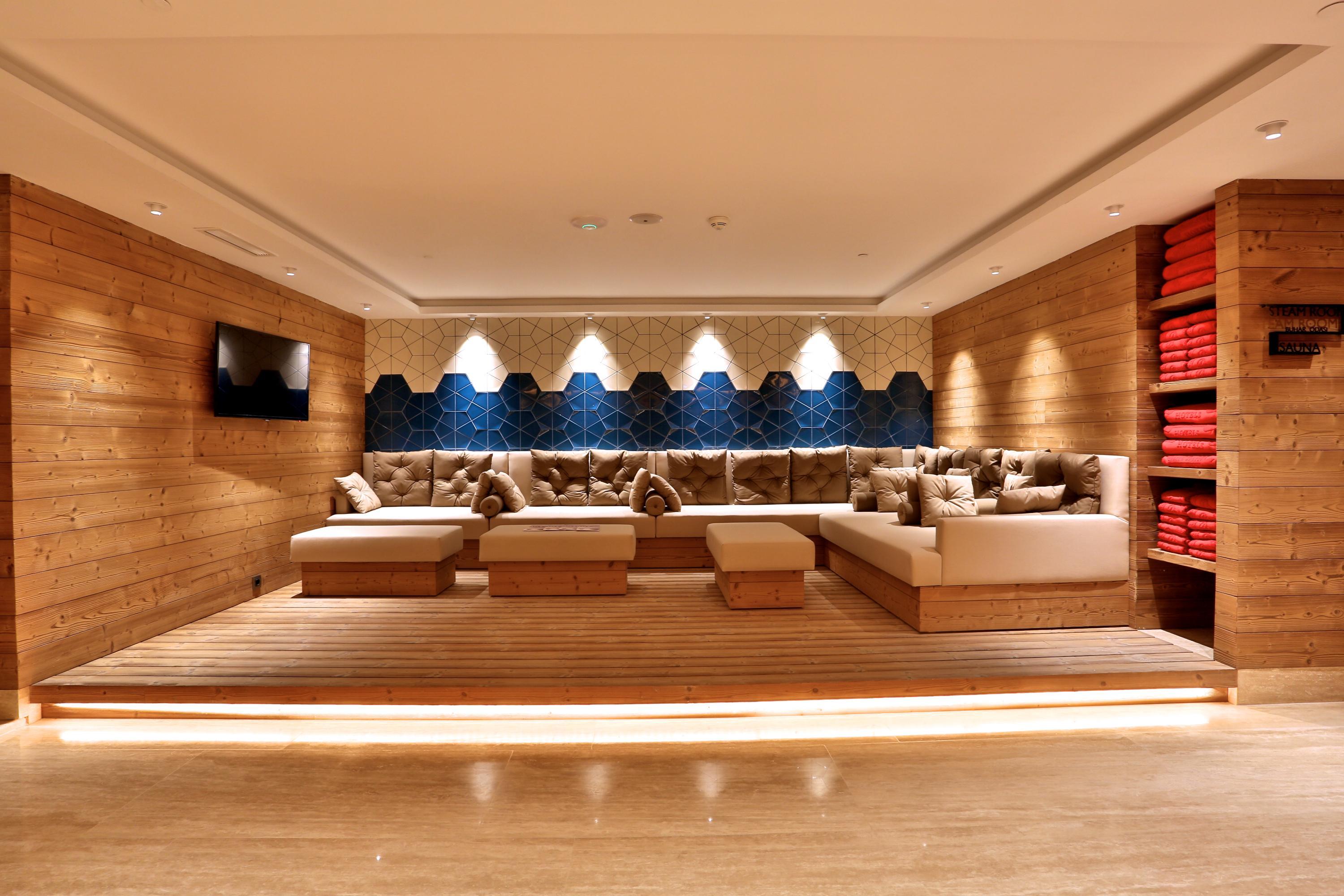Dosso Dossi Hotels & Spa Downtown Istambul Exterior foto The photo shows a cozy and modern lounge or relaxation area. It features wooden walls and a light-colored wooden floor, creating a warm atmosphere. The seating consists of plush couches with decorative cushions in neutral tones, arranged around a low