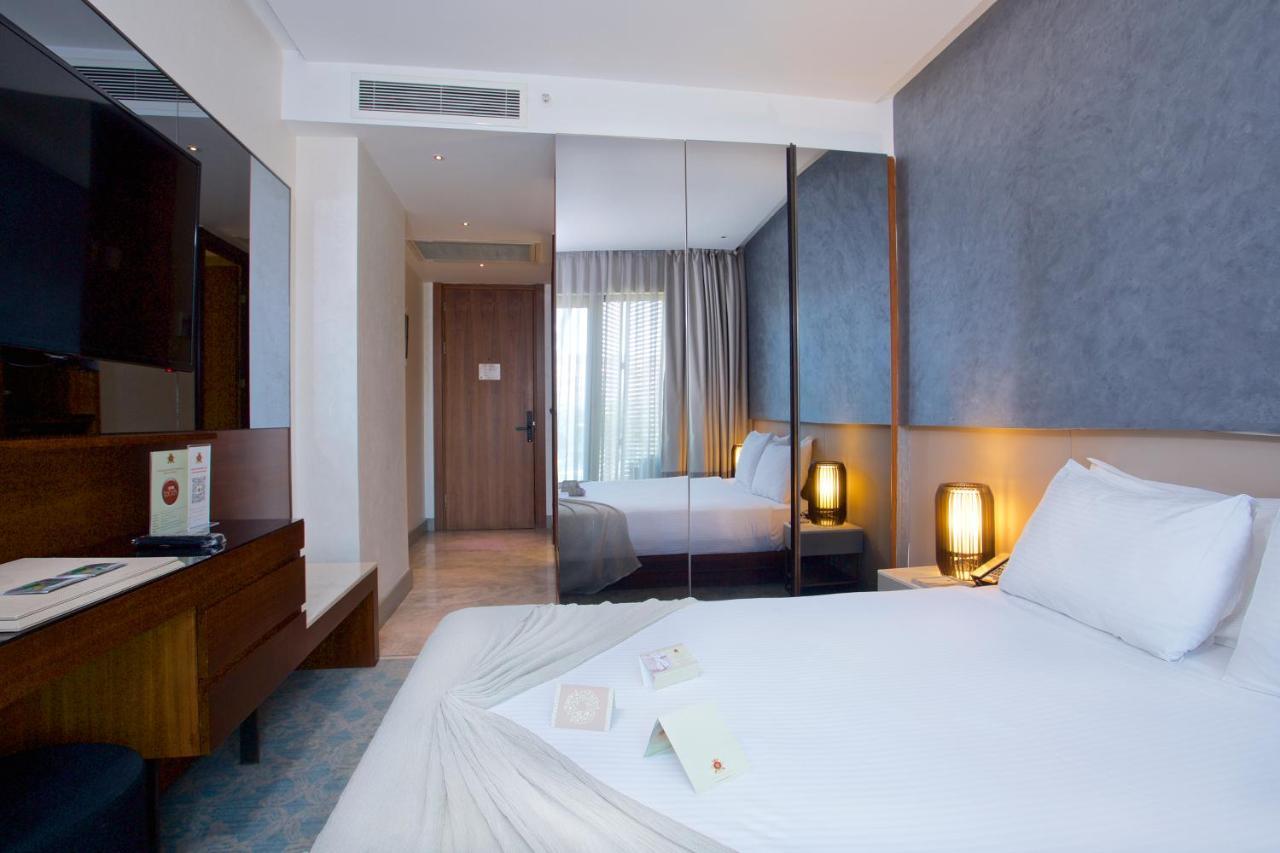 Dosso Dossi Hotels & Spa Downtown Istambul Exterior foto The photo shows a modern hotel room. It features a neatly made bed with white linens, and there are decorative items placed on the bed. The room has a contemporary design with light-colored walls and a large window allowing natural light to enter. 

