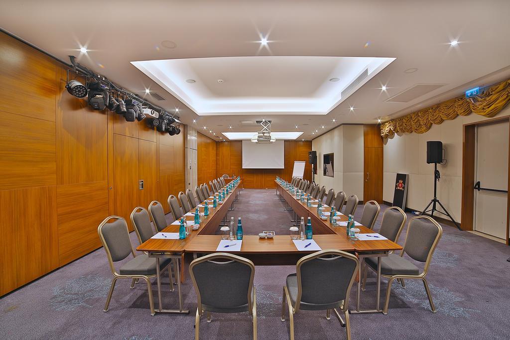 Dosso Dossi Hotels & Spa Downtown Istambul Exterior foto The photo shows a conference room set up for a meeting. There are two long tables arranged in a rectangular shape, with several chairs placed around them. Each chair has a small bottle of water and a notepad on the table in front of it. The room feat
