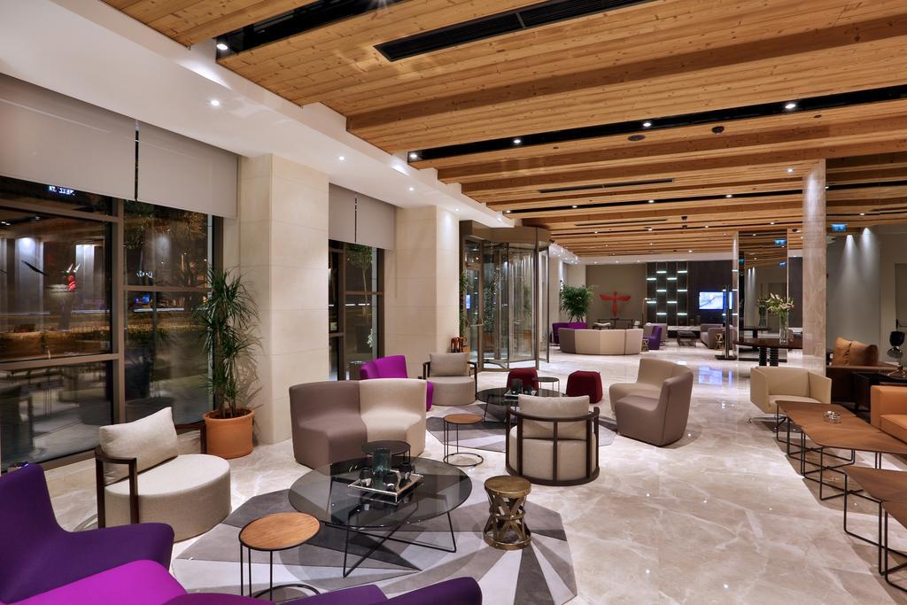 Dosso Dossi Hotels & Spa Downtown Istambul Exterior foto The photo shows a modern and stylish lobby or lounge area. It features a combination of comfortable seating options, including a mix of chairs and sofas in various shapes and colors, such as purple and beige. The space is well-lit with natural light 